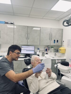 Dr Alireza Samadi dentist at Dulwich Dental Centre in East Dulwich showing treatment results to a patient after dental implants